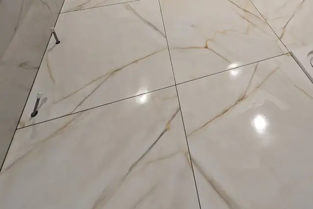 Large format marble-effect porcelain floor tiles with gold veining